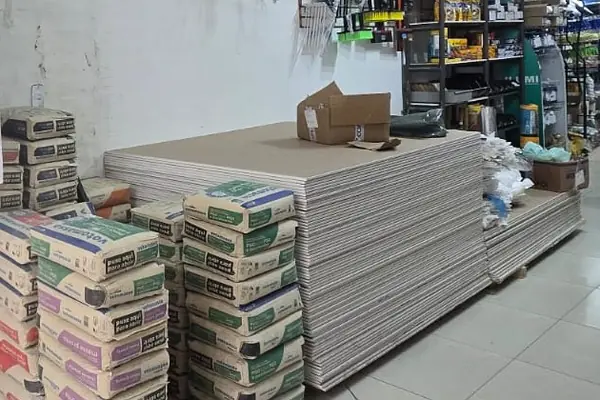 Placas e sacos de material empilhados na área interna da loja